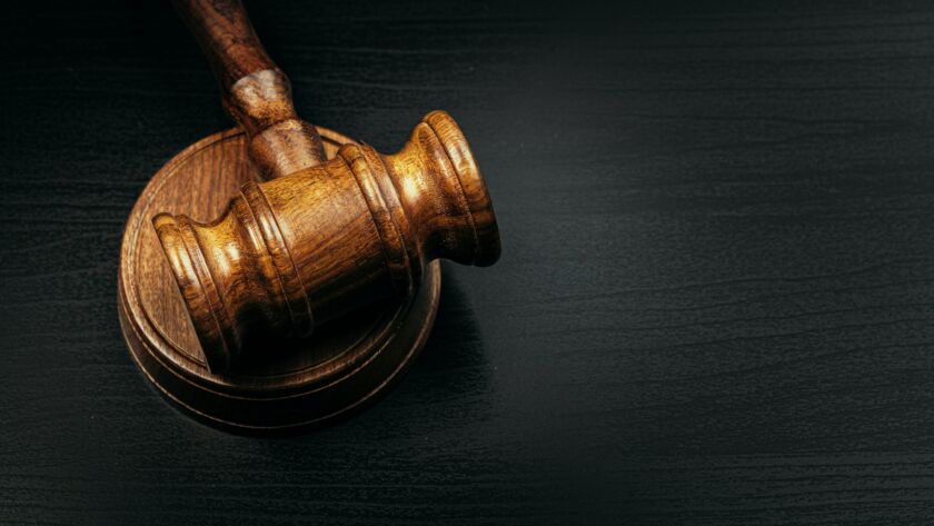 Judge's gavel on wooden table in dark