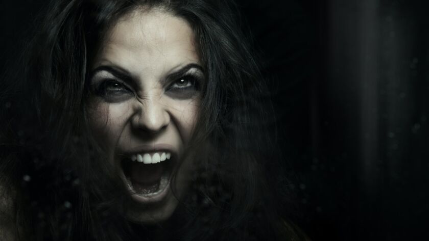 Screaming witch behind the wet glass